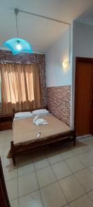 Bett in einem Zimmer mit Ziegelwand in der Unterkunft Star Sianna Village Rooms to let in Siána