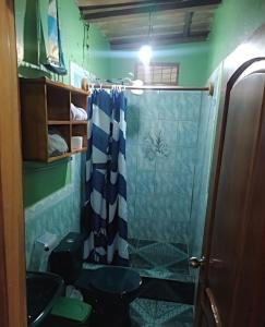 ein Bad mit einer Dusche mit einem blauen und weißen Duschvorhang in der Unterkunft La casa de los Ciprés in San Cristobal