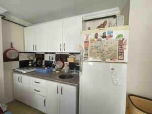 una cucina con armadietti bianchi e frigorifero di Lux Apartment+Terrace a Mardin