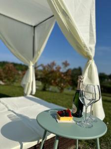 a table with a bottle of wine and a plate of food at Holiday Home Sovenigo in Puegnago