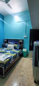 2 łóżka w pokoju z niebieskimi ścianami w obiekcie Kishori ram guest house 5 minute walking distance from railway station w mieście Ayodhya