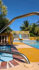 - une piscine dans un complexe avec des palmiers dans l'établissement Yukayeke Playa Resort, à Anasco