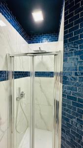 een douche in een badkamer met blauwe tegels bij Casa Vacanze De Gasperi 210 in Castellammare di Stabia