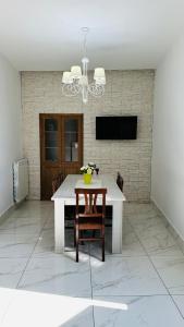 een eetkamer met een tafel en stoelen en een televisie bij Casa Vacanze De Gasperi 210 in Castellammare di Stabia
