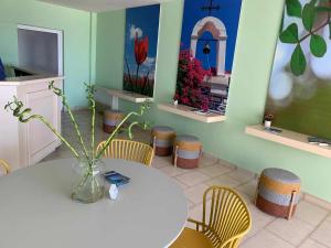 CHIOS HOTEL في Katarráktis: طاولة مع كراسي و مزهرية عليها زهور