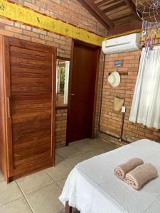 Schlafzimmer mit einem Bett und einer Holztür in der Unterkunft Morada Crisálida in Praia do Rosa