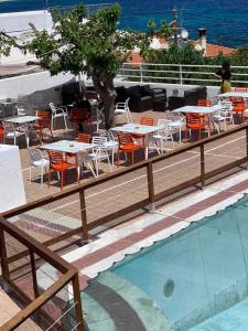 CHIOS HOTEL في Katarráktis: فناء به طاولات وكراسي بجانب مسبح
