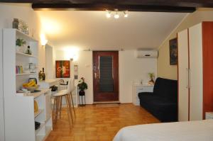 a room with a bed and a kitchen with a couch at Guest House Most in Buzet