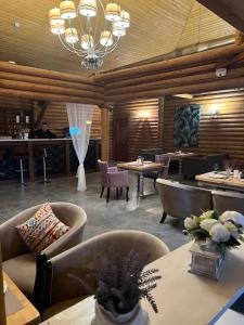 ein Restaurant mit Tischen und Stühlen und eine Bar in der Unterkunft Soho Hutor in Bosteri