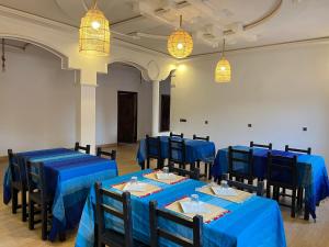 a room with blue tables and chairs and lights at Merzouga Lodge in Merzouga