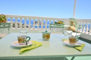 einen Tisch mit zwei Tassen und Platten darauf in der Unterkunft Villa Eleonora, un angolo di Paradiso ad Ischia in Ischia