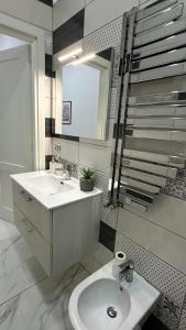 een witte badkamer met een wastafel en een spiegel bij Casa Vacanze De Gasperi 210 in Castellammare di Stabia
