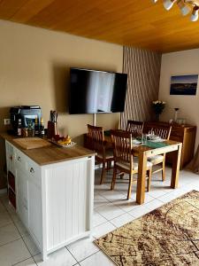 uma cozinha e sala de jantar com uma mesa e uma televisão em Ferienwohnung Schluchseeblick em Schluchsee