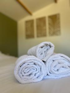 una pila de toallas sentadas encima de una cama en Le Patio, chambres d hôtes pour adultes en Camargue, possibilité de naturisme à la piscine,, en Aimargues