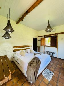 a bedroom with a bed and a bench in it at Rancho do Buna in Atins