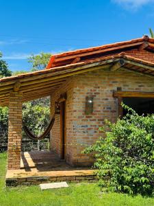 un edificio de ladrillo con una puerta abierta en el césped en Rancho do Buna en Atins
