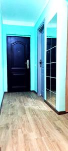 een kamer met een zwarte deur en een houten vloer bij Mogosoaia High Living Mansion in Chitila