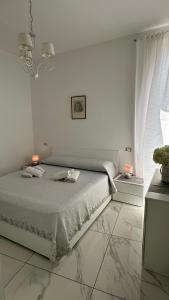 een witte slaapkamer met een bed met 2 lampen erop bij Casa Vacanze De Gasperi 210 in Castellammare di Stabia