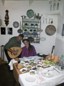 Um homem e uma mulher sentados à mesa com comida. em Eco Nitovikla 