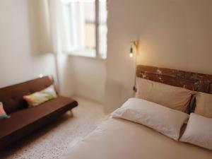 a bedroom with a bed and a couch and a window at Città Vecchia in Bitonto