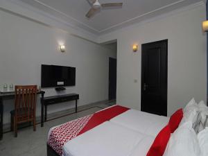 Dormitorio con cama, escritorio y TV en Golden Cafe en Chennai