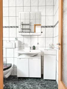 a white bathroom with a sink and a mirror at Im Herzen von Wermelskirchen II in Wermelskirchen