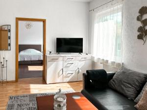 a living room with a couch and a television at Im Herzen von Wermelskirchen II in Wermelskirchen
