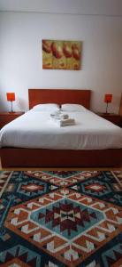 a bedroom with a bed with a rug and two lamps at Jardiv's Apart in Ponta Delgada
