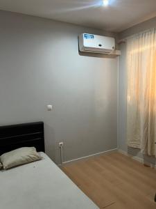 a bedroom with a bed and a air conditioner on the wall at T1 Família Luz in Mindelo