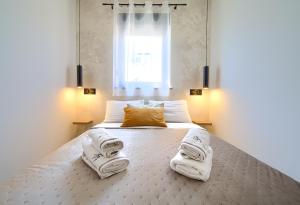 a bedroom with a bed with towels on it at Apartments Sinisa - Krk Town in Krk