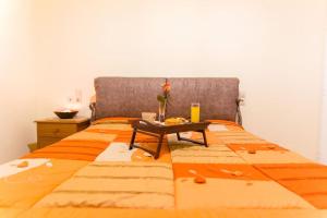 an orange bed with a table on top of it at Cosy stone-built home “Hellen” in Krousón