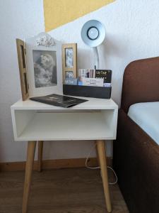 a white table with a bed and a lamp on it at Vintage-Zimmer mit Balkon in Felsberg
