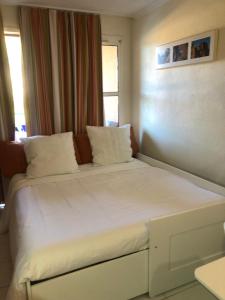 a bed with white sheets and pillows in a room at Appartement à Cap Estérel Village Pierre et Vacances Piscines et parking inclus in Agay - Saint Raphael +49 photos