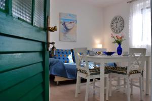 a dining room with a table and chairs and a clock at Holiday house Silvana in Ždrelac