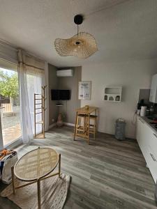 a living room with a table and a kitchen at Studio calme avec jardin in Canet-en-Roussillon