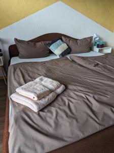 a bed with two towels sitting on top of it at Vintage-Zimmer mit Balkon in Felsberg