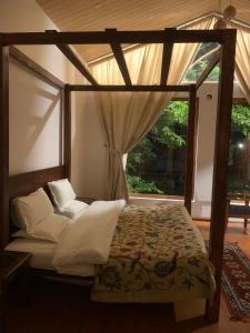 1 dormitorio con cama con dosel y ventana en Nigeen Vista Lakeside Chalet en Srinagar