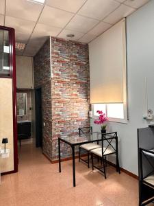a room with a table and chairs and a brick wall at stop & go in Arbós