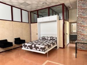 a bedroom with a bed and two black chairs at stop & go in Arbós