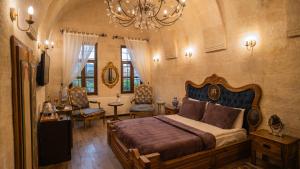 a bedroom with a large bed and a chandelier at Yeşil Konak Cave Hotel in Ürgüp
