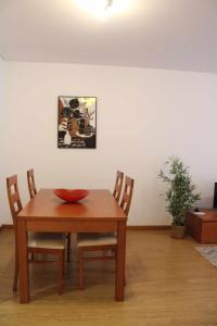 a wooden table with two chairs and a bowl on it at Jardiv's Apart in Ponta Delgada +7 photos