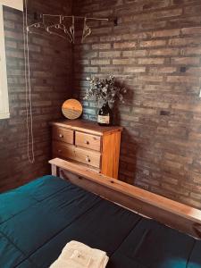 1 dormitorio con cama y tocador de madera en Lo de Lito en Sierra de la Ventana