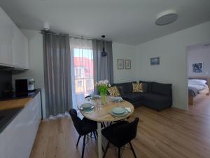 Una cocina y una sala de estar con mesa y sillas. en Apartament u Moniki, en Międzywodzie
