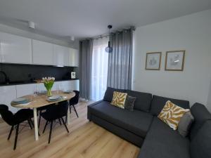 una sala de estar con un sofá y una mesa en Apartament u Moniki, en Międzywodzie