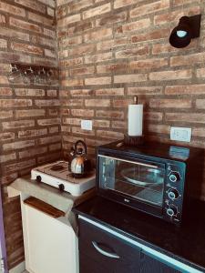 a kitchen with a microwave and a stove at Lo de Lito in Sierra de la Ventana