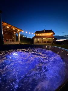 une grande piscine d'eau bleue devant une maison dans l'établissement Wolf Guest House, à Alba Iulia