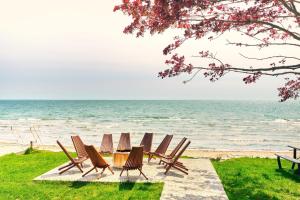 a group of chairs and a table on the beach at TheLongBeachResort - Beachfront Cottages & Townhouse Suites in Wainfleet