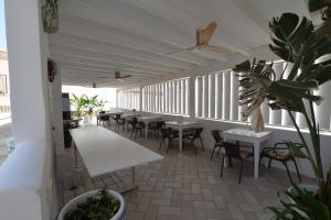 an empty restaurant with tables and chairs and plants at Palazzo Salapolis - Luxury Apartments in Gallipoli