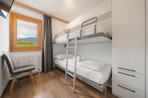 1 Schlafzimmer mit 2 Etagenbetten und einem Stuhl in der Unterkunft Luxus Apartment Kaprun View in Kaprun