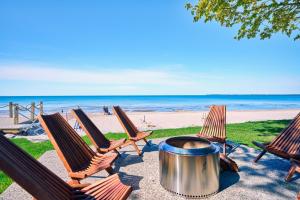 a group of chairs and a barrel on the beach at TheLongBeachResort - Beachfront Cottages & Townhouse Suites in Wainfleet